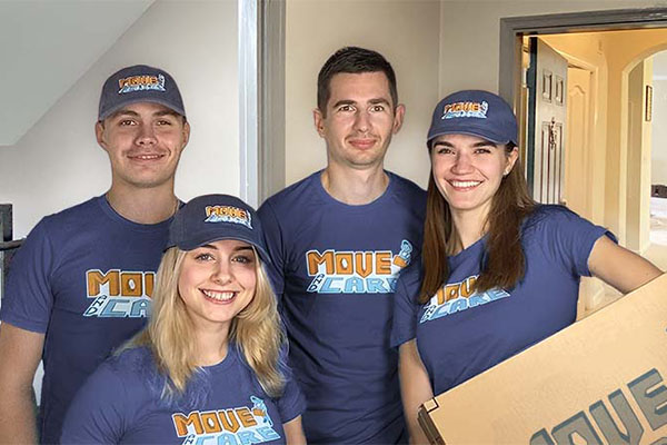 Four smiling Move and Care crew members in branded caps and shirts