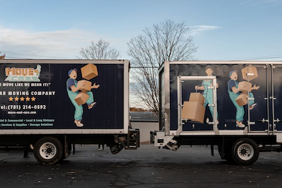 Two Move and Care box trucks parked side by side