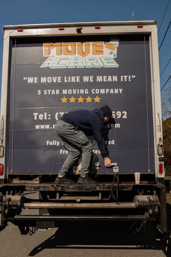 Move and Care mover operating the rear lift gate of a moving truck