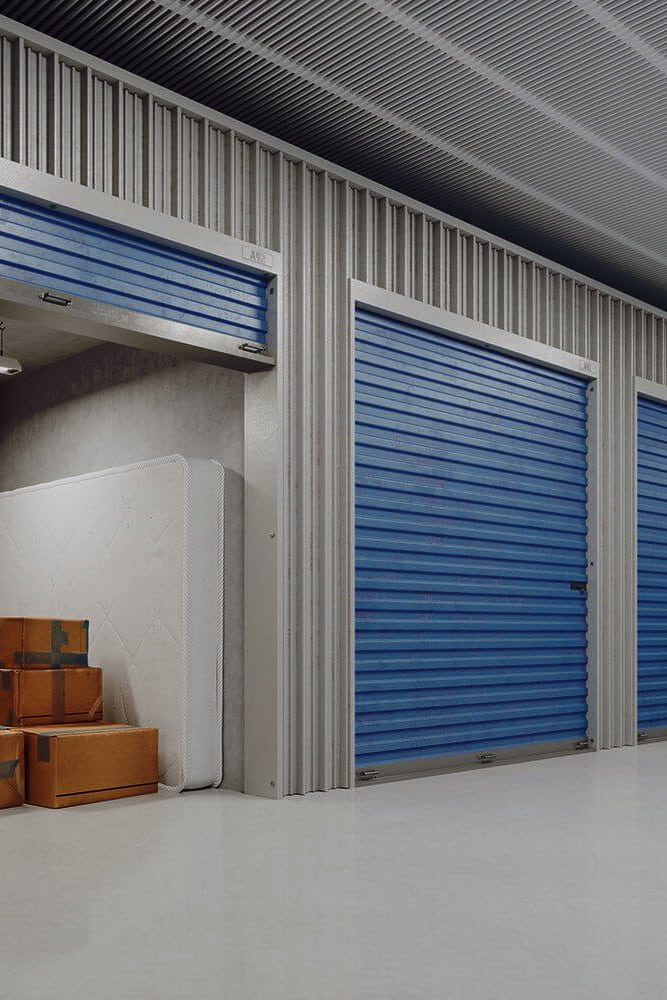 Storage facility units with packed moving boxes and a wrapped mattress